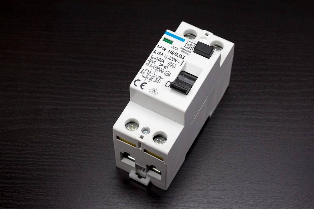 เครื่องตัดไฟรั่วสีขาวแบบติดราง มีคันโยกสีดำและปุ่มทดสอบ ระบุพิกัด 0.03A